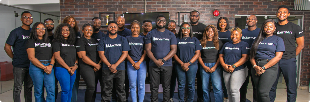 Jobberman careers page featuring a team photo of 20 employees standing in front of a brick wall, all wearing Jobberman-branded t-shirts. Above the image, there is a headline encouraging visitors to "Discover Your Future with Jobberman" and to "Be a part of the Jobberman Crew," with a call-to-action button to explore careers.